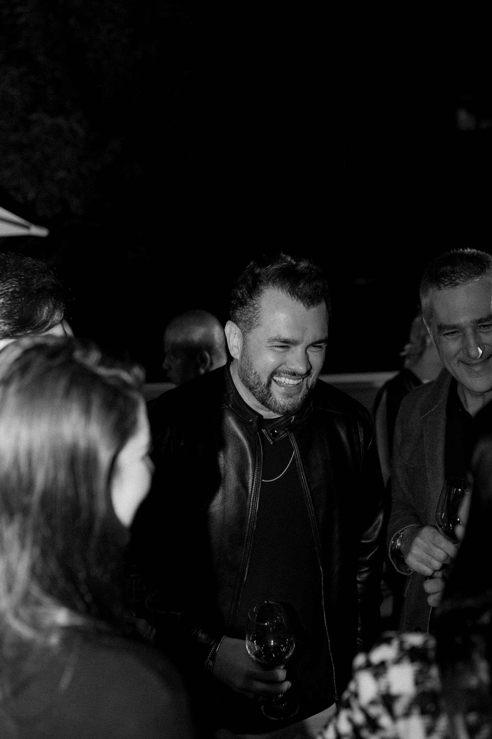 Convidados conversando em evento noturno no The Roof 448, em preto e branco